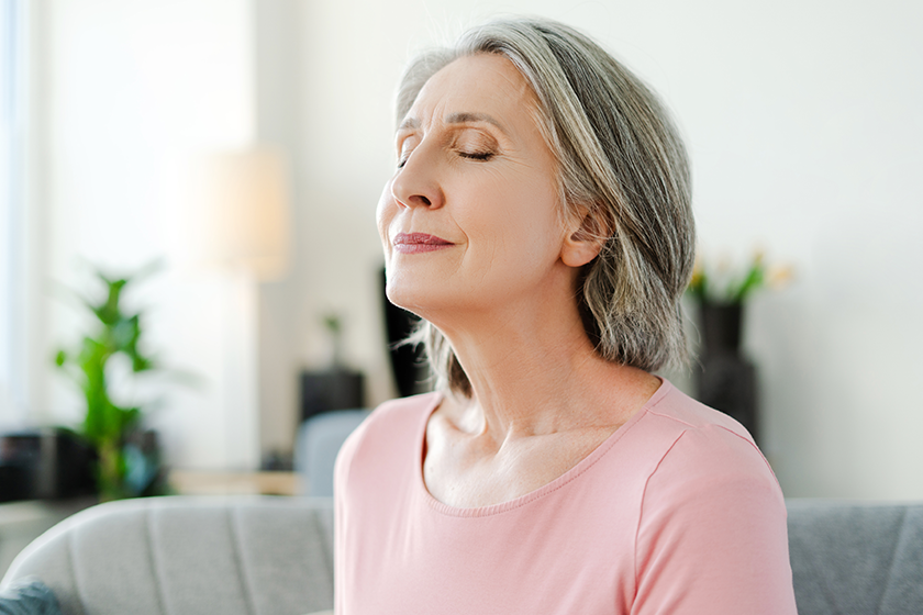 smiling-active-senior-woman-sitting-closed-eyes-comfortable-sofa-relaxing